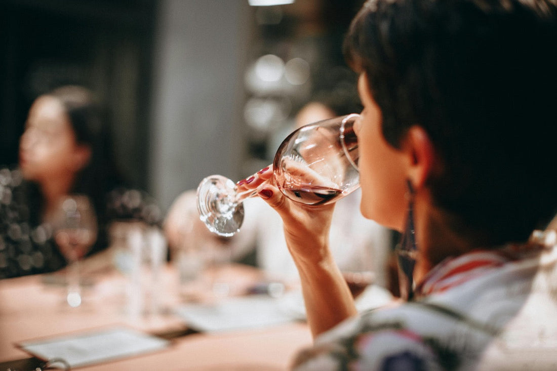 A woman in her 40's enjoying a glass of low histamine wine with friends