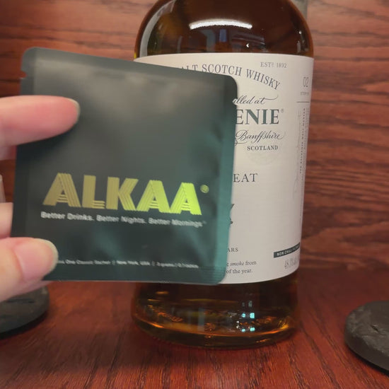Front of ALKAA Singles Pack in front of Scotch bottle.