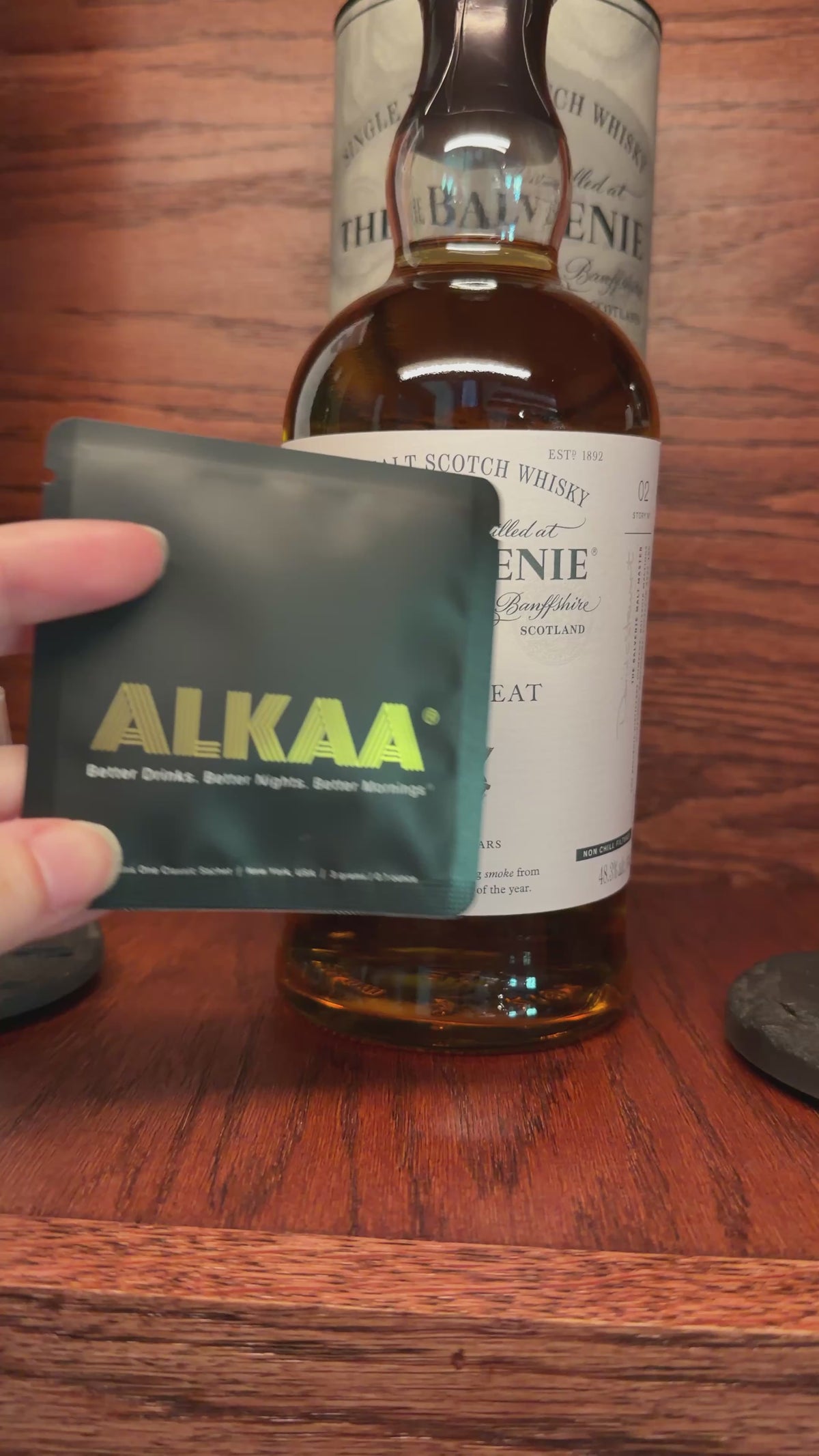 Front of ALKAA Singles Pack in front of Scotch bottle.